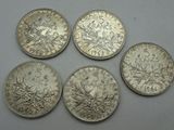 four silver coins are shown on a white surface