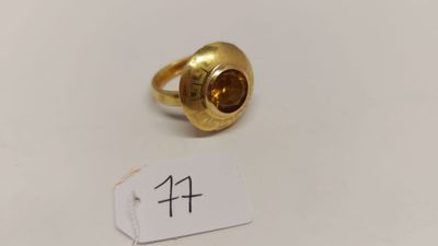 une image représentant une bague en or sertie d'une pierre marron