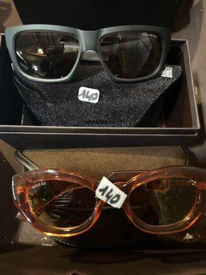 deux paires de lunettes de soleil rangées dans une boîte avec une étiquette de prix