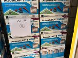 Des cartons d'Acquizap 2 Nex sont empilés les uns sur les autres dans un magasin