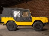 a yellow jeep with a black cover parked in a garage