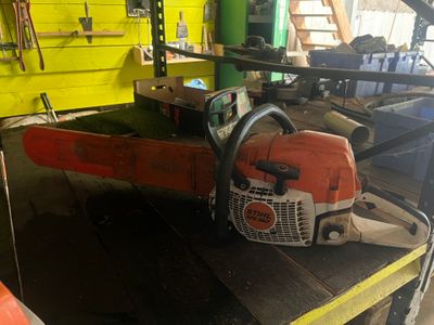 une tronçonneuse posée sur un établi dans un garage
