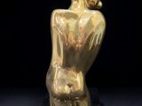 a gold statue of a woman holding a child on a black base