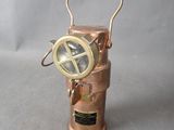 an image of a small copper lantern with a compass on it