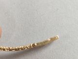 someone is holding a piece of gold that has been placed on a white surface