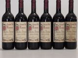 six bouteilles de vin sont alignées sur une table