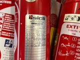 several red fire extinguisors are lined up on a shelf