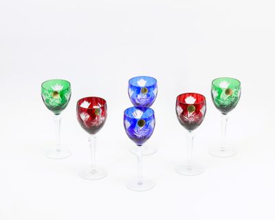 quatre verres à vin sont alignés sur une surface blanche