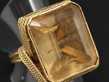 Gros plan sur une bague contenant une pierre jaune