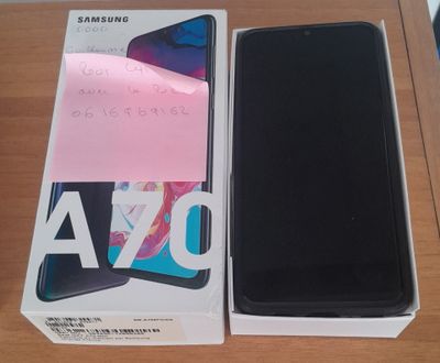 Samsung A70 avec sa boîte et son emballage, posé sur une table en bois