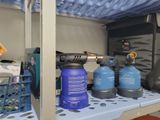 a shelf with a lot of different types of gas bottles on it