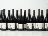six bouteilles de vin sont alignées sur une table