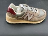 the new balance 995 is a beige and red sneak with a tan sole