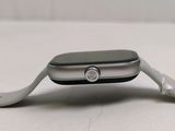 a silver apple watch sitting on a white surface
