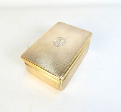 une photo d'un étui à cigarettes en or posé sur une table blanche