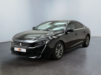 La voiture noire est garée dans une pièce blanche au sol noir.