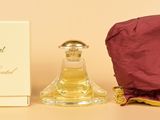 un petit flacon de parfum à côté d'une petite boîte