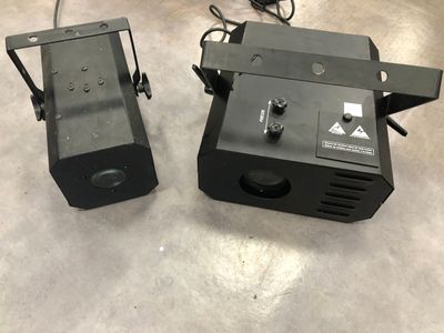 two black speakers sitting on top of a floor next to each other