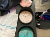 three clocks sitting on a table next to a pile of papers
