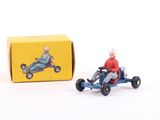 toy figurine of an old man driving a toy car in front of a box