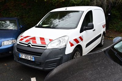 a white van parked in a parking lot next to a blue car