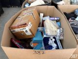 une boîte en carton remplie d'objets, posée par terre
