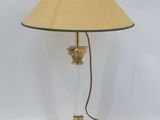 une photo d'une lampe de table avec un pied en verre et un abat-jour doré