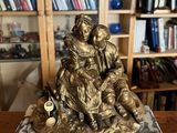 a statue of a woman holding a child on a marble base
