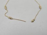 a gold beaded necklace on a white background
