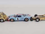 three toy cars sitting next to each other on a white surface