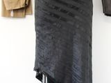 a black skirt on a mannequin stand in front of a white wall
