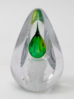 a glass vase with a green flower inside of it