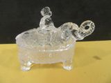 un éléphant en verre posé dans un bol sur une table jaune