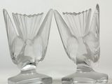 pair of clear glass vases sitting on top of a metal stand