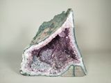 a close up of a piece of rock with purple and green crystals on it