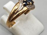 a close up of a gold ring with a blue stone