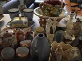 a table that has many different types of vases and plates on it