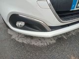 a close up of a white car with a blue license plate on it
