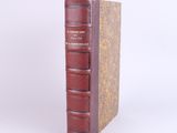 an old book sitting on top of a table next to a white wall