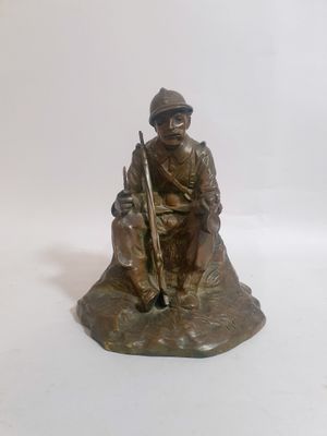 statue représentant un homme assis sur un rocher, un fusil à la main