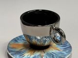 a cup and saucer on a saucer on a white table