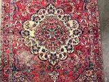 an antique persian rug with a medallion design on a red ground