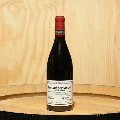 a bottle of wine sitting on top of a barrel