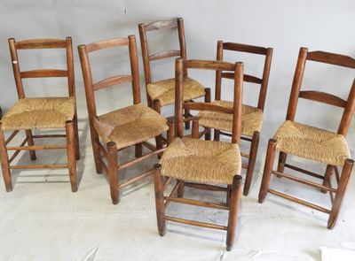six chaises en bois sont alignées sur un sol blanc