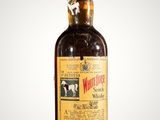 an old bottle of whiskey sitting on top of a table