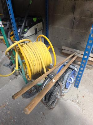 un tuyau jaune posé sur un chariot dans un garage