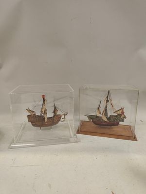 deux bateaux miniatures dans une vitrine posée sur une table