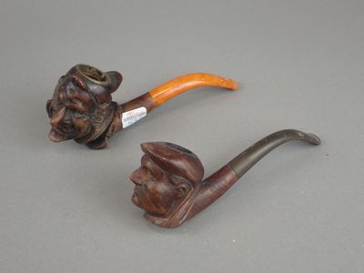 une paire de têtes de pipe sculptées et une pipe sculptée représentant un visage d'homme