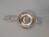 a silver bowl with a spoon in it on a table