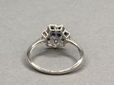 une photo d'une bague sertie d'un diamant et d'un saphir posée sur une table